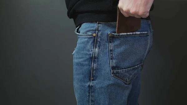 L'homme sort la poche avec de l'argent des jeans. Gros plan — Photo