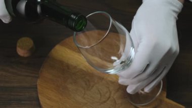 Bardaklar alkolik beyaz şarapla doluyor.