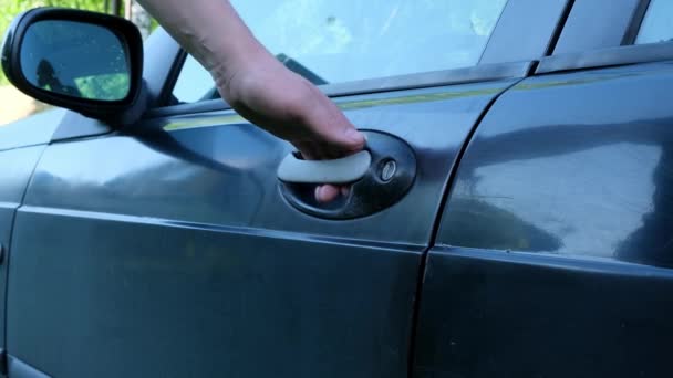 Чоловік відкриває свої двері чорного автомобіля Крупним планом — стокове відео