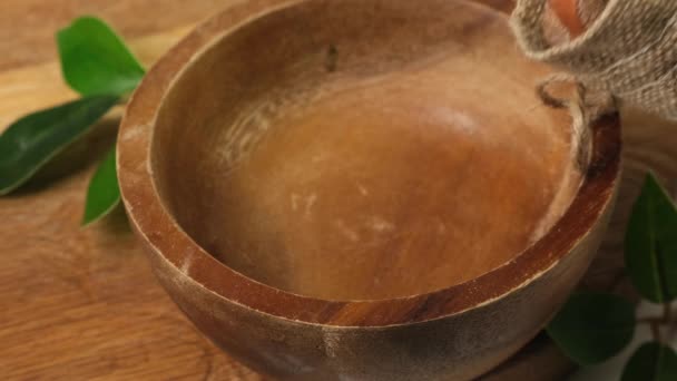 하젤 넛 을 갈색 나무 그릇에 붓는다. 닫아 — 비디오