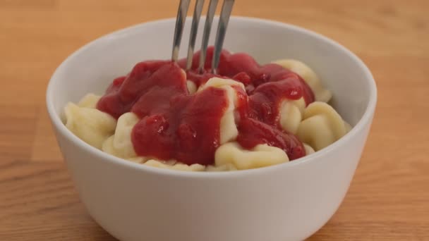 Mann isst Knödel mit Ketchup einer Gabel. Nahaufnahme — Stockvideo