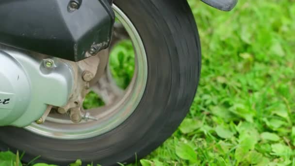 Крупный план колеса мотоцикла в парке. — стоковое видео