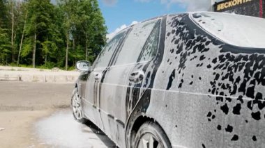 Siyah araba köpük dökülüyor. Yakından.