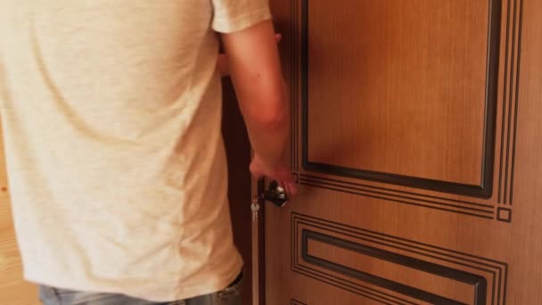 Мужская рука открывает деревянную дверь в комнате. Закрыть. — стоковое видео