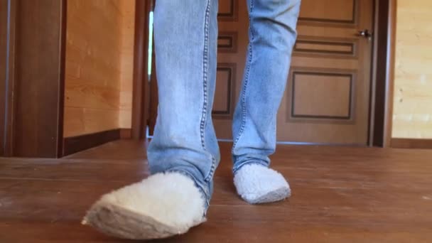一个穿拖鞋的男人在屋里的地板上走着 — 图库视频影像