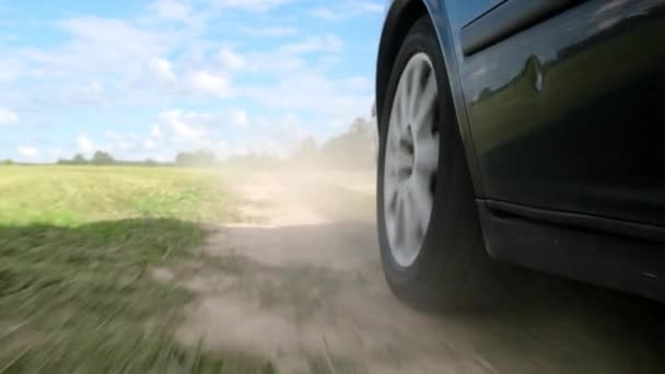 Lose up the wheel of a car moving across the field. — Stock Video