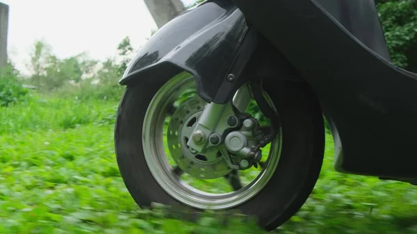 Vorderrad des Motorrollers im Freien auf grünem Gras. — Stockfoto