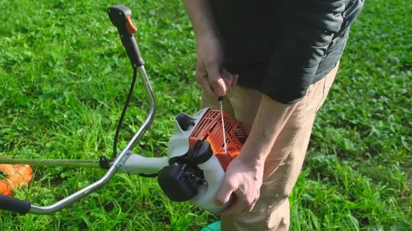 Professional lawn mower starts his new gas lawn trimmer — Stock Photo, Image