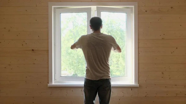 Um homem fecha uma janela de plástico branco pelo punho. — Fotografia de Stock