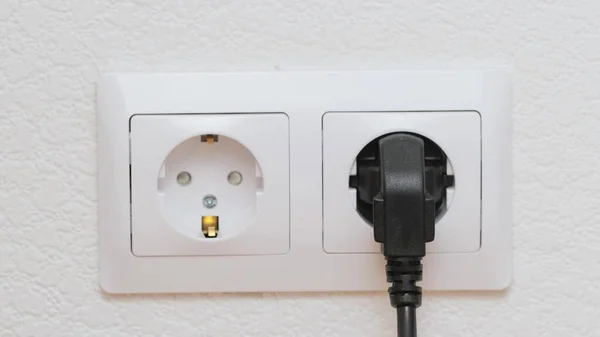 Inserting an electric plug in socket on the wall Close up — Stock Photo, Image