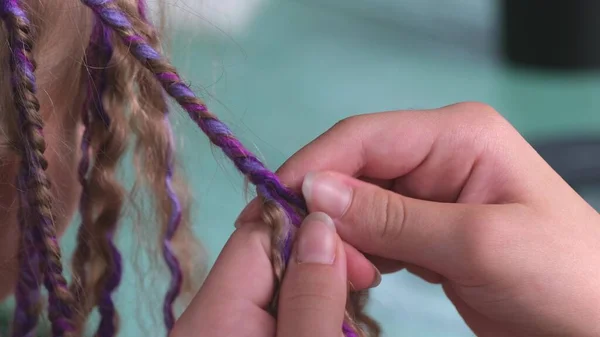 Vrouwelijke handen met weven een vlecht uit haar bij de kapper closeup — Stockfoto