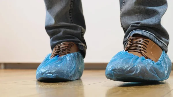 Man goes in shoe covers to the doctor — Stock Photo, Image