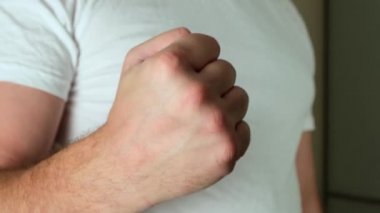 Saldırganlığını göstermek için yumruğunu salla. Kapat.