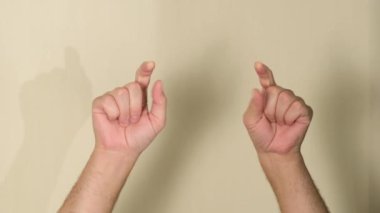 Erkek eller, stüdyoda bej turuncu bir arka planda izole edilmiş bir şekilde, kopyalama alanını işaret ediyor. Reklam alanını kopyala. Metin veya grafik reklam içeriği için boşluk ile.