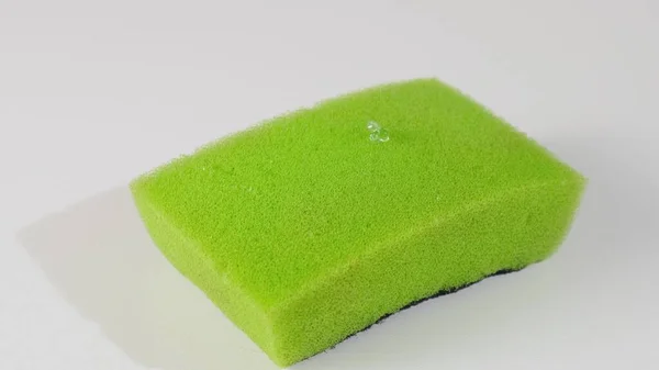 Super macro gros plan vert d'éponge jaune pour plat et détergent à verser sous forme de gel vert. gros plan — Photo