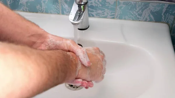 Las manos de una persona se lavan en el fregadero con espuma —  Fotos de Stock