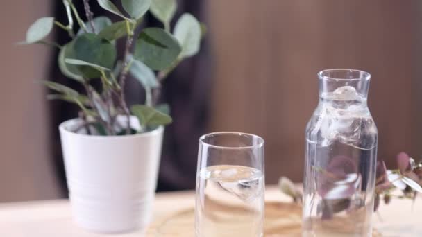 Verter agua mineral de carbonato en un vaso con hielo. Movimiento lento. — Vídeos de Stock