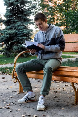 Şehir parkında kitap okuyan adam.