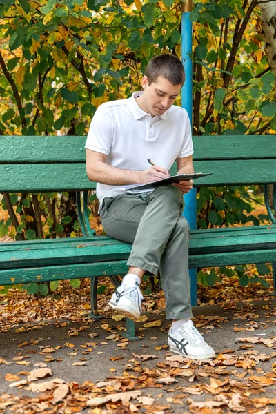 Hombre Escribe Cuaderno Rodilla —  Fotos de Stock