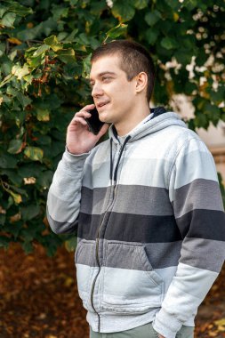 Bankta oturan akıllı telefon kullanan mutlu bir adamın profili.