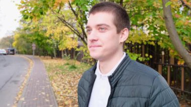 Yakışıklı, neşeli bir adam sokakta duruyor. Kapat.