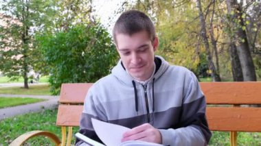 Doğada elinde kitap olan genç bir adam. Bir insan kitap okur..