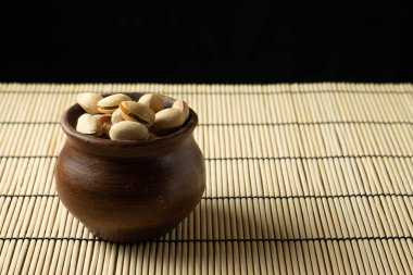 Masanın üzerinde bir kil kase fıstık