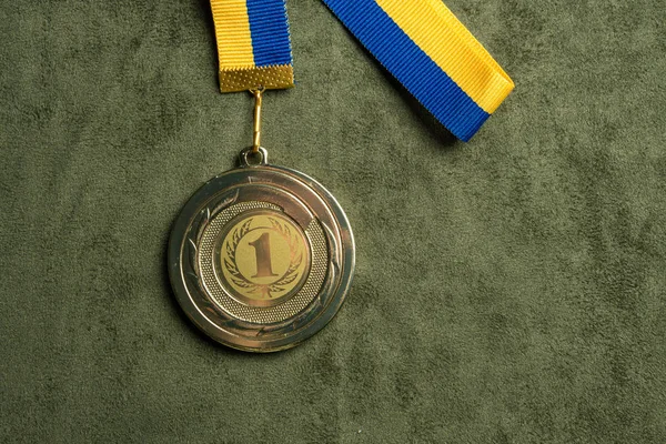 Gold medal for first place with yellow and blue ribbon — Stock Photo, Image