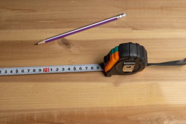 Mezura ve kalem bir parça tahta arka plan üzerinde