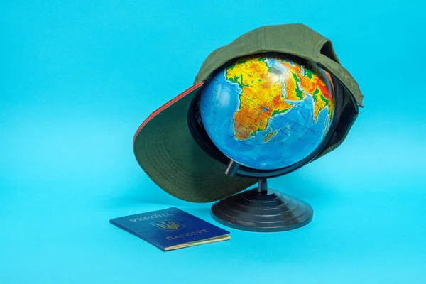 Passport of a citizen of Ukraine near the globe with a baseball cap