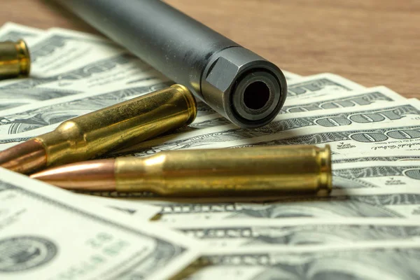 Rifle barrel, magazine and cartridges on money. Concept for crime, contract killing, paid assassin, terrorism, war, global arms trade, weapons sale. Illegal hunting, poaching