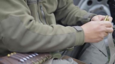 Avcı ya da avcı tüfeği durdurur. Bir adamın elleri tüfek dükkanına fişek yerleştiriyor, yakın plan.