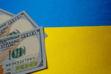 Ukrayna ulusal bayrağı ve dolar banknotları. İş ve finans kavramı, yumuşak odaklanma