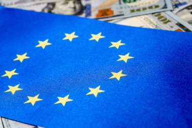 Arka planda Amerikan doları bulunan Avrupa Birliği bayrağı. Yatırımcılar için kavram, yumuşak odaklanma