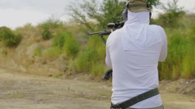 Adam tüfeğini doldurur ve dikiz aynasından ateş eder.