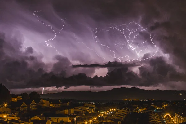 猛烈な雷は静かな町の横に落ちる 魔法のライトと雷と空の色 ストック写真