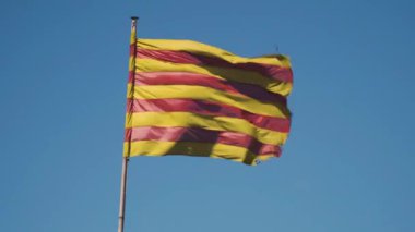 Catalonia, İspanya, resmi bayrağı ağır nedeniyle güçlü bir rüzgar sallıyor. Şeritli bayrak renkleri sarı ve kırmızı.
