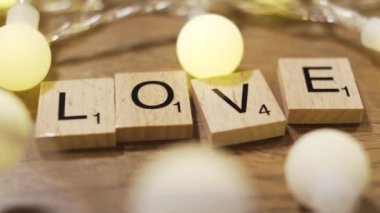 Kelime aşk ışıkları ile çevrilidir. Mektup mektup blok ile oluşur. Aşk bir oyundur.