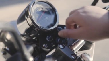 Birisi bir motosiklet üzerinde açmak için tuşuna döner.