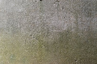 Soyut bir arka plan olarak sarı ve kahverengi lekeler ile eski gri beton duvar