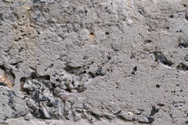 Soyut bir arka plan olarak sarı ve kahverengi lekeler ile eski gri beton duvar