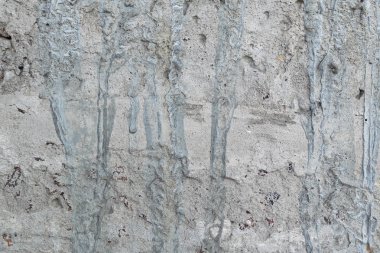 Soyut bir arka plan olarak sarı ve kahverengi lekeler ile eski gri beton duvar