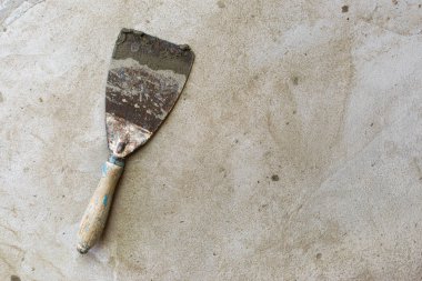 Mala tamiri için inşaat aracı gri-kahverengi çimento ve beton üzerinde yatıyor