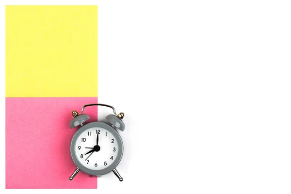 Ρολόι Ένα Ξυπνητήρι Λευκό Φόντο Βρίσκεται Χρωματιστό Χαρτί Φύλλα Από — Φωτογραφία Αρχείου