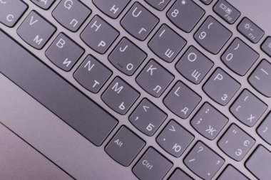 Internet'e bağlı modern klavyesi ve bilgisayar ağı olan gümüş grisi dizüstü bilgisayar, ofisteturuncu bir masaüstünde yer alır