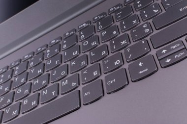 Internet'e bağlı modern klavyesi ve bilgisayar ağı olan gümüş grisi dizüstü bilgisayar, ofisteturuncu bir masaüstünde yer alır