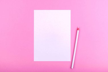 Pembe bir arka plan üzerinde yatan notlar, metinler, çizimler ve notlar için beyaz bir kağıt levha yanında beyaz bir kalem