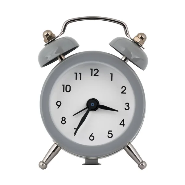 A gray clock with an alarm clock on a white background with arrows showing the time three hours thirty five minutes or fifteen hours thirty five minutes