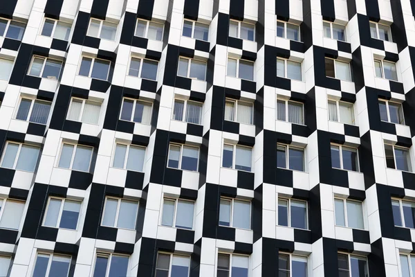 The wall of the office center building in the form of black and white checkerboard-like cells for an abstract background