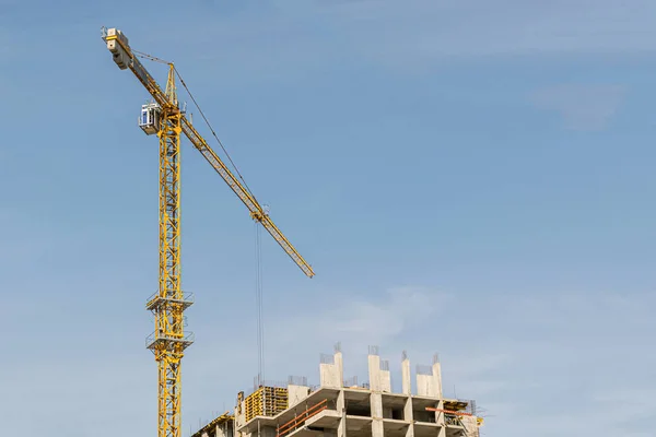 Een Gele Hoogbouw Kraan Tegen Een Blauwe Lucht Bouwt Meerdere — Stockfoto